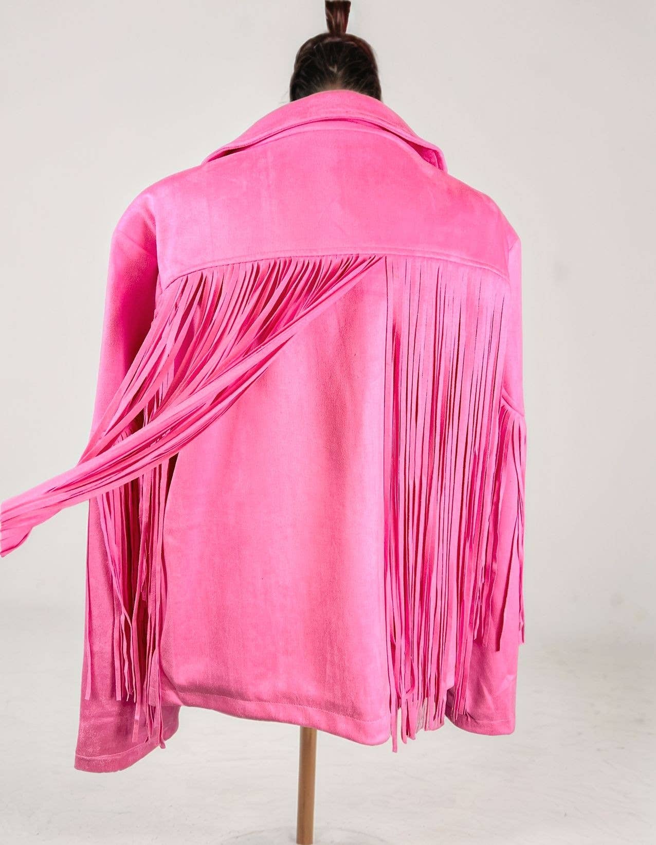 Pink fringed jacket on a mannequin against a white background