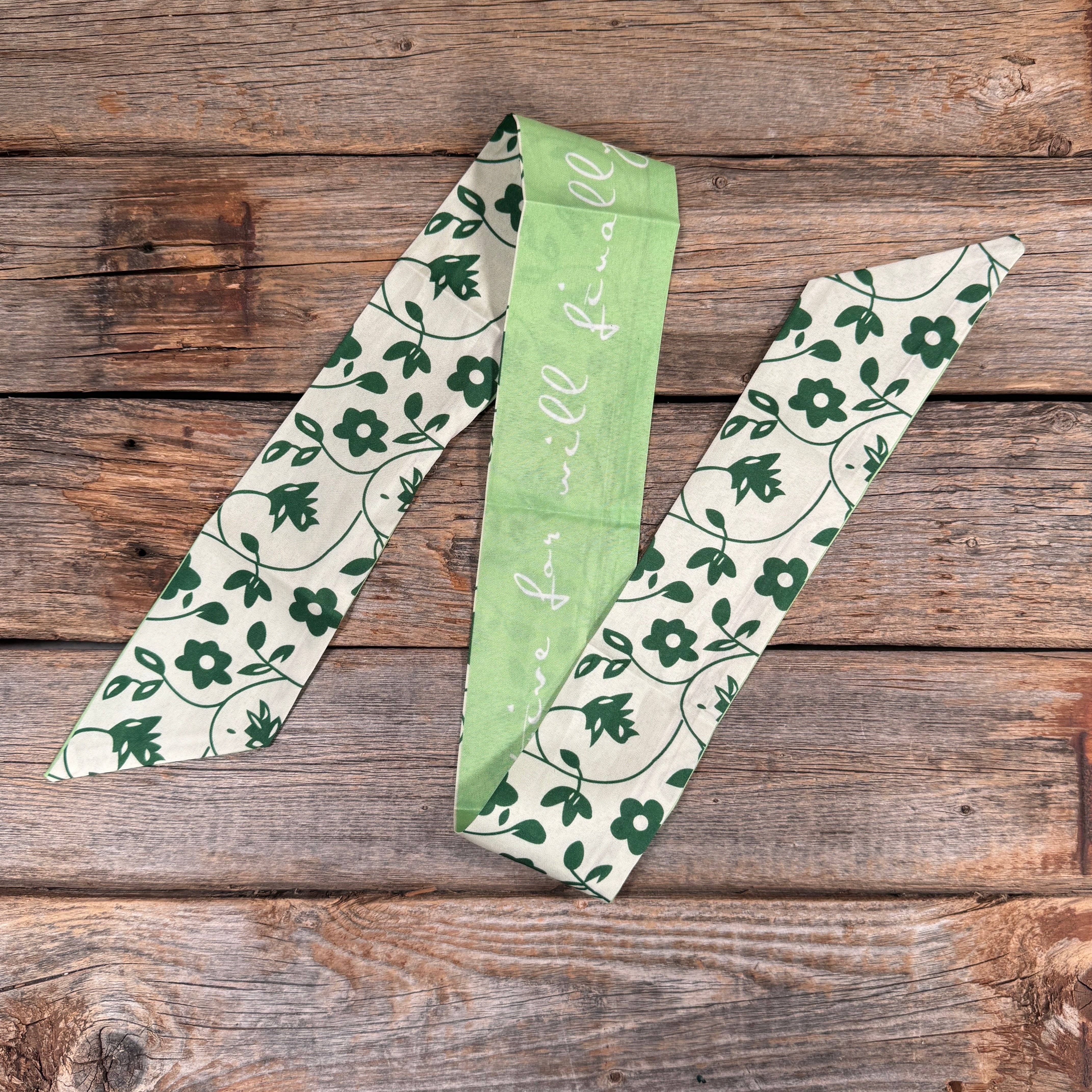 Three green and white patterned ribbons on a wooden surface