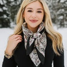 Woman wearing a patterned scarf in a snowy outdoor setting