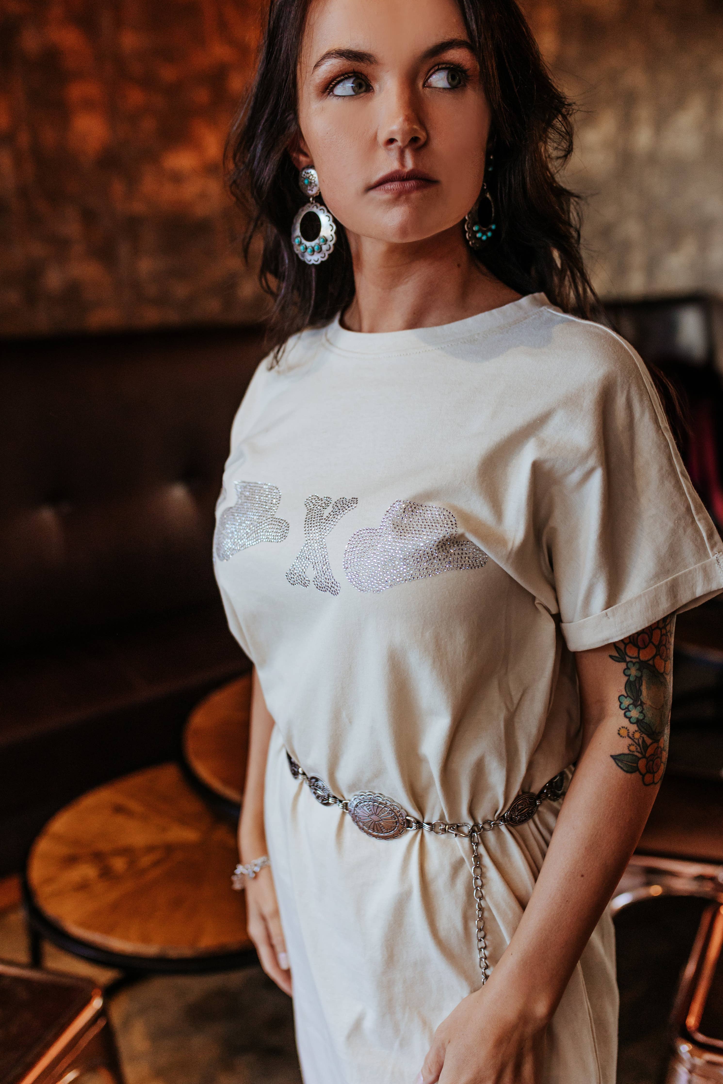 Woman wearing a white dress with floral patterns in an indoor setting