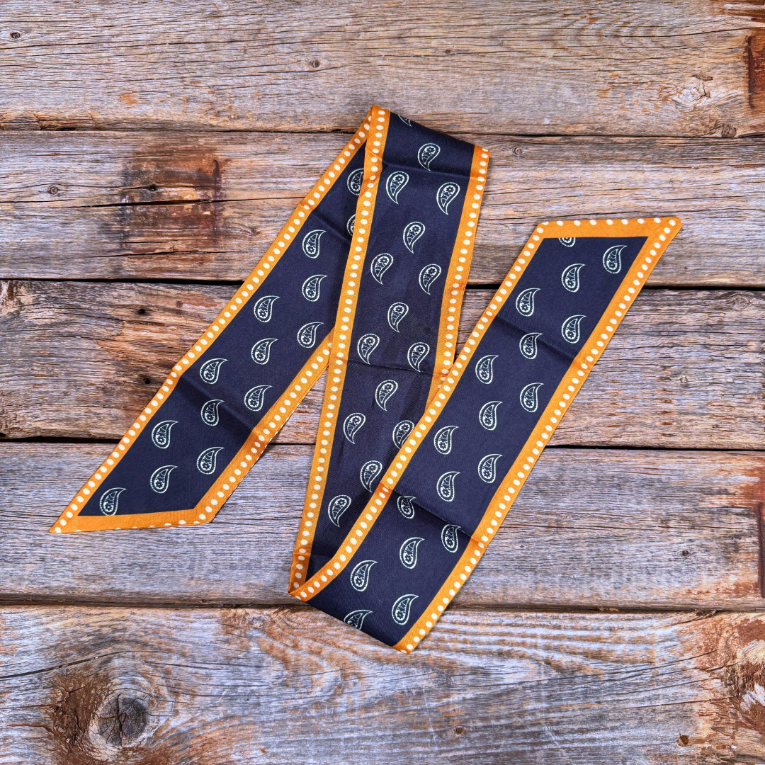 Navy blue necktie with mustard border on a wooden surface