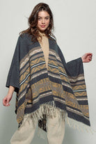 Dark gray poncho with brown and beige striped pattern and fringes on a white background