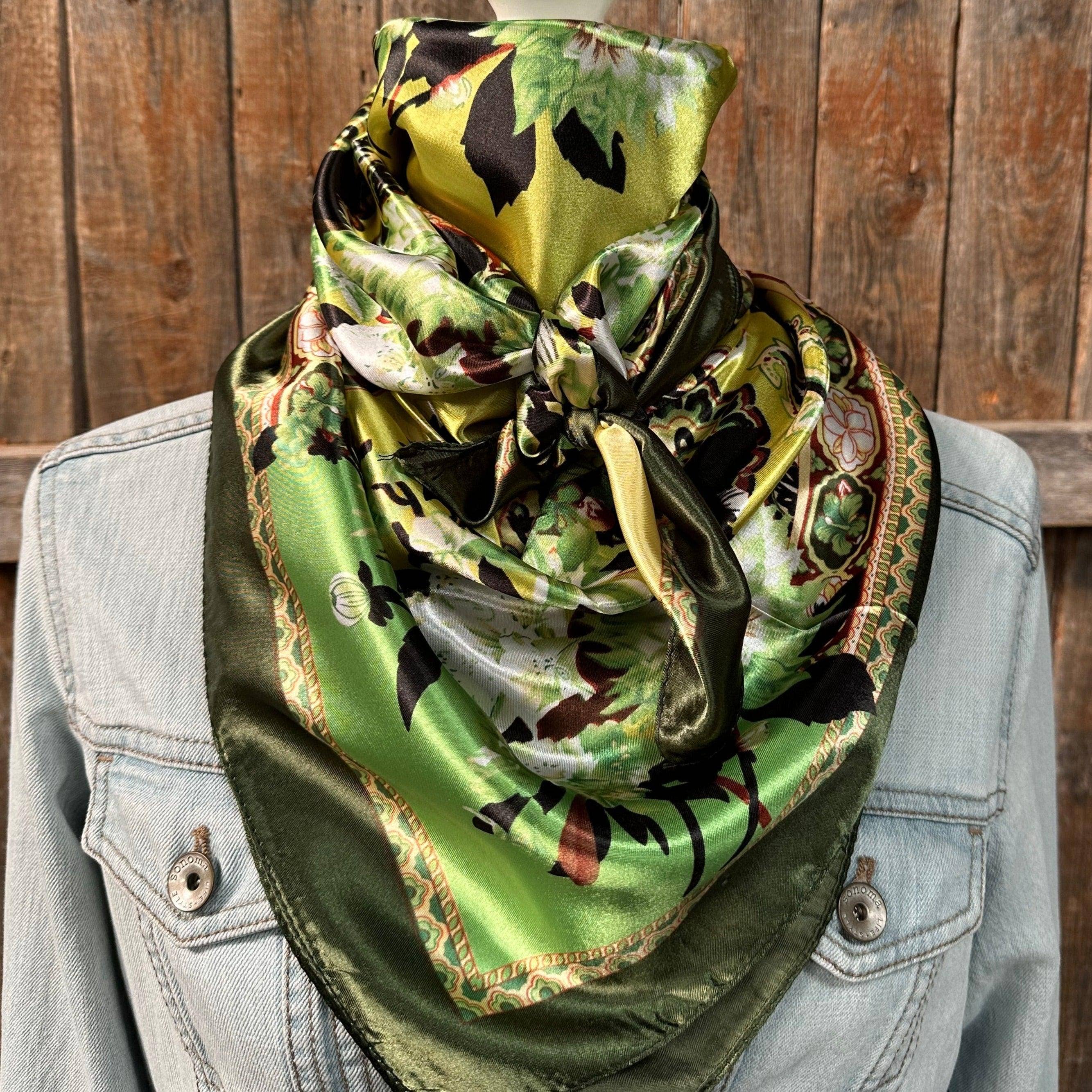 Green patterned scarf draped over a denim jacket against a wooden background