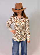 Person wearing a patterned shirt and brown hat against a plain background