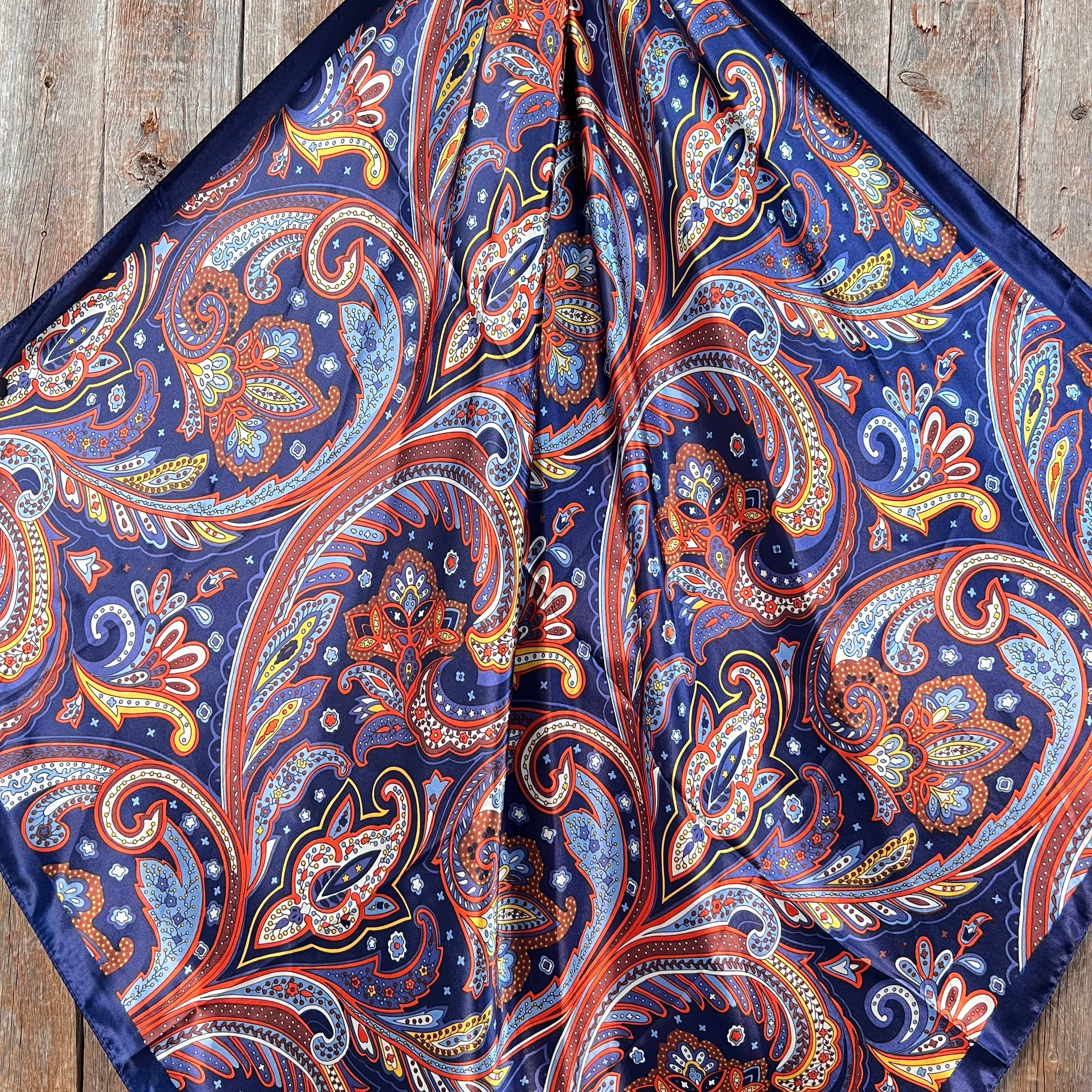 Close-up of a colorful paisley patterned scarf on a wooden surface