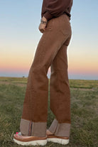 Side and back view of Sand Cat Cuffed Jeans highlighting the flattering high-rise fit, functional back pockets, wide-leg silhouette, and contrast cuff.